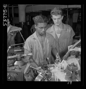 Fritz Henle, photographer. NYA National Youth Administration work center, Brooklyn, New York. A Negro bench-lathe worker, who is receiving training in machine shop practice, gauging a screw just removed from the collet. New York New York State United States, 1942. Aug.?. Photograph. Retrieved from the Library of Congress, https://lccn.loc.gov/2017866473. (Accessed November 02, 2017.)